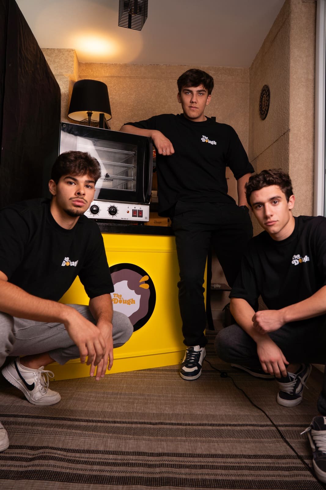 Os três sócios fundadores da The Dough no estúdio, ao redor do forno e da caixa amarela